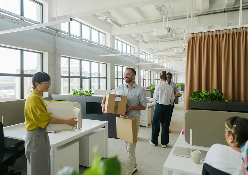 Professional movers relocating office equipment and business supplies.