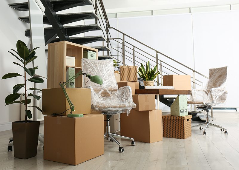 Office furniture and cardboard boxes packed for a move.