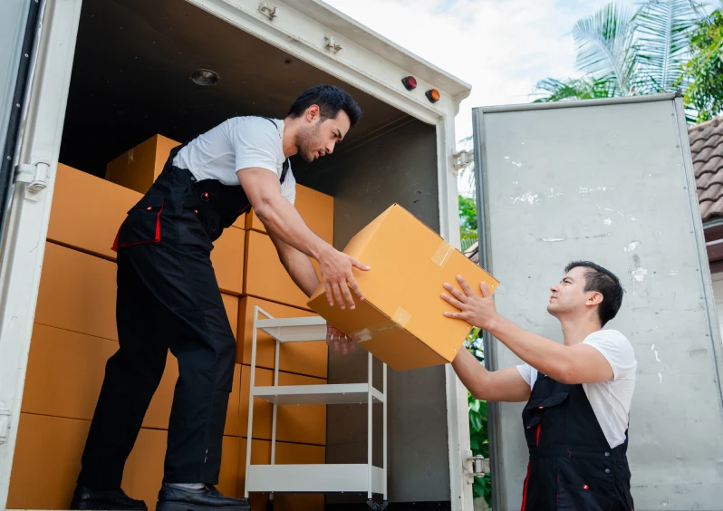 Workers loading oversized items for specialized moving services.
